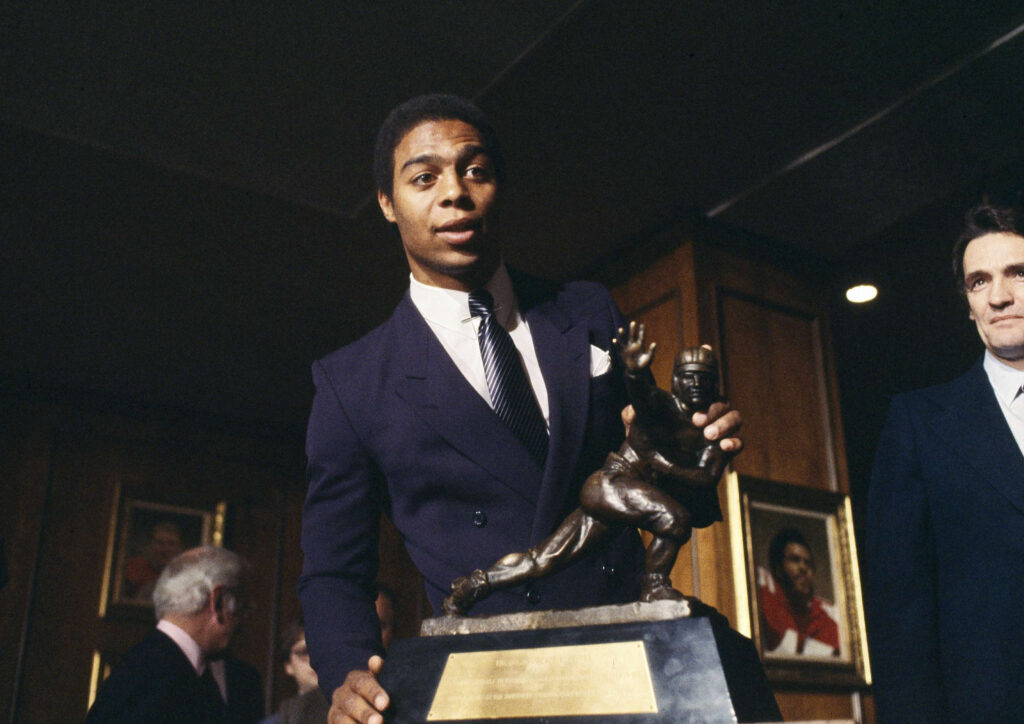Marcus Allen of the USC Trojans poses with the coveted Heisman Trophy awarded to him at the Downtown Athletic Club in New York on Dec. 6, 1981. Allen, 21, who traversed more football turf than any other player in college football history, was the 47th winner of the Heisman. Photo credit: Ron Frehm, The Associated Press