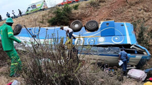 In this photo made available by the South African Department of Transport and Community Safety, police officers and emergency rescue workers search for victims from a bus lying upside down in an embankment in Louis Trichardt, South Africa, on Sunday, Oct. 12, 2025. Photo courtesy of South African Department of Transport and Community Safety via The Associated Press