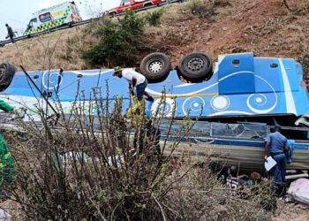In this photo made available by the South African Department of Transport and Community Safety, police officers and emergency rescue workers search for victims from a bus lying upside down in an embankment in Louis Trichardt, South Africa, on Sunday, Oct. 12, 2025. Photo courtesy of South African Department of Transport and Community Safety via The Associated Press