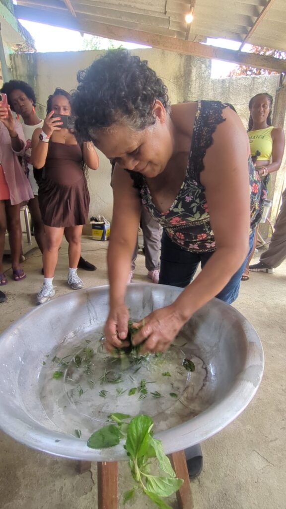 Quilombo leader Maria Lúcia prepares an herbal bath in which Black Travel Summit attendees were able to wash their hands, in Rio de Janeiro in November 2025. Photo credit: Kiratiana Freelon, Black News & Views