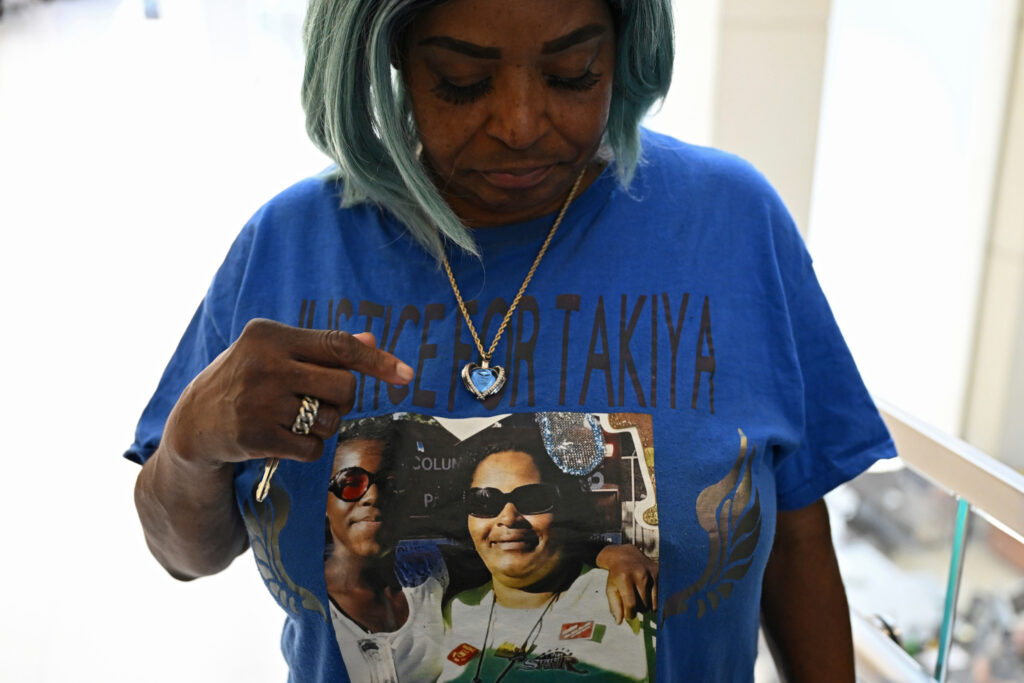 Nadine Young, grandmother of Ta'Kiya Young, shows her shirt to reporters after arraignment proceedings of Blendon Township, Ohio, police officer Connor Grubb, on Aug. 14, 2024, at the Franklin County Court of Common Pleas in Columbus. Photo credit: David Dermer, The Associated Press