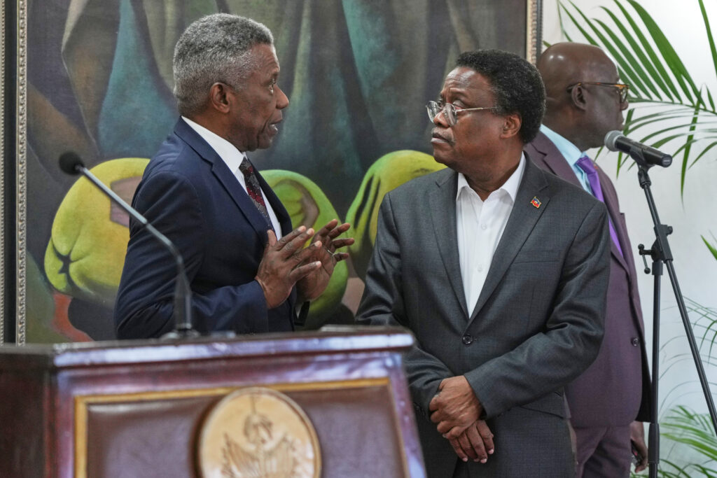 Chief of Protocol of the National Palace Marc Marie Yves Mazile speaks to Fritz Alphonse Jean, a member of Haiti’s transitional presidential council, before the start of a press conference in Port-au-Prince, Haiti, Ton uesday, Nov. 25, 2025. Photo credit: Odelyn Joseph, The Associated Press